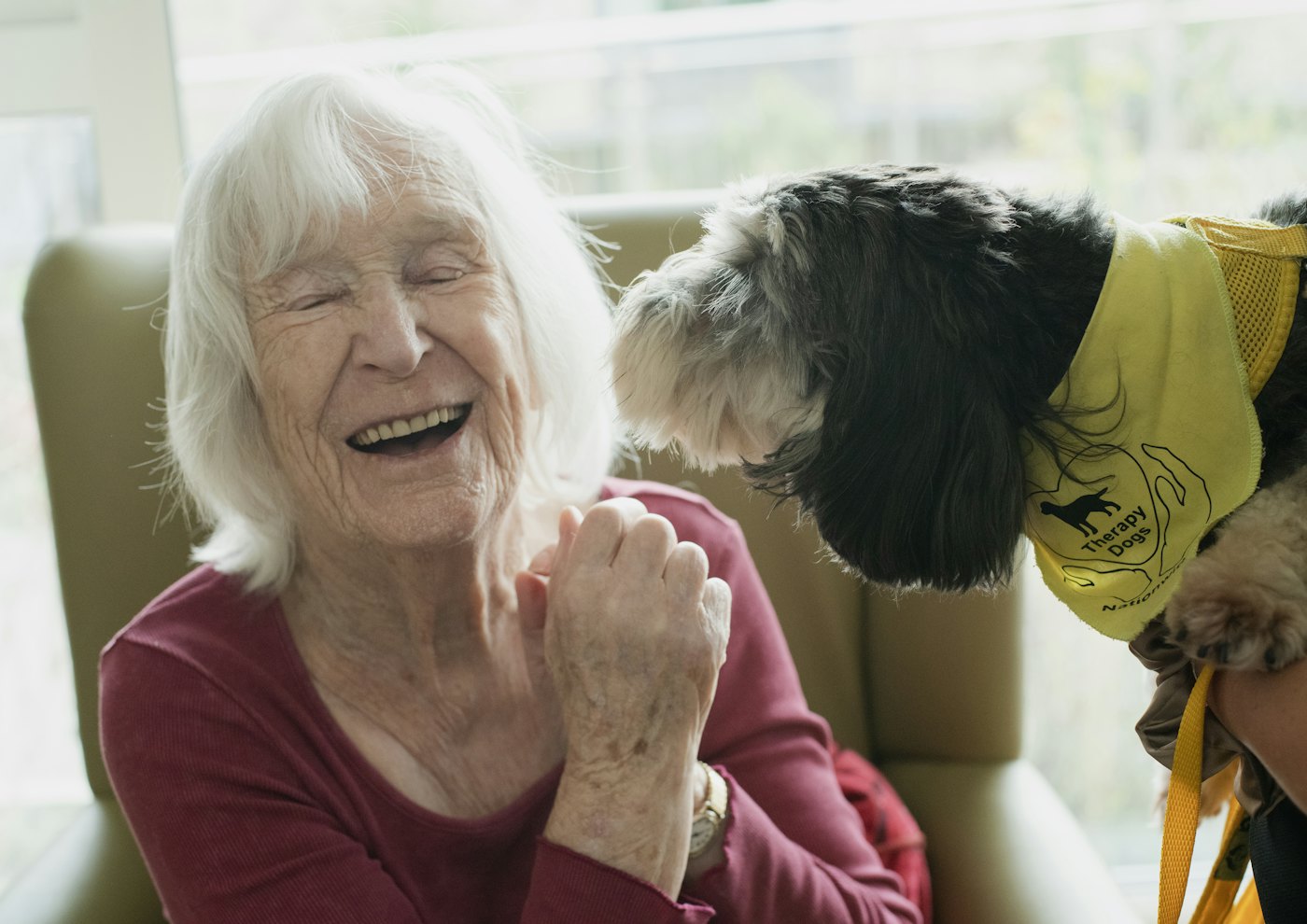 Elderly woman laughing with her dog