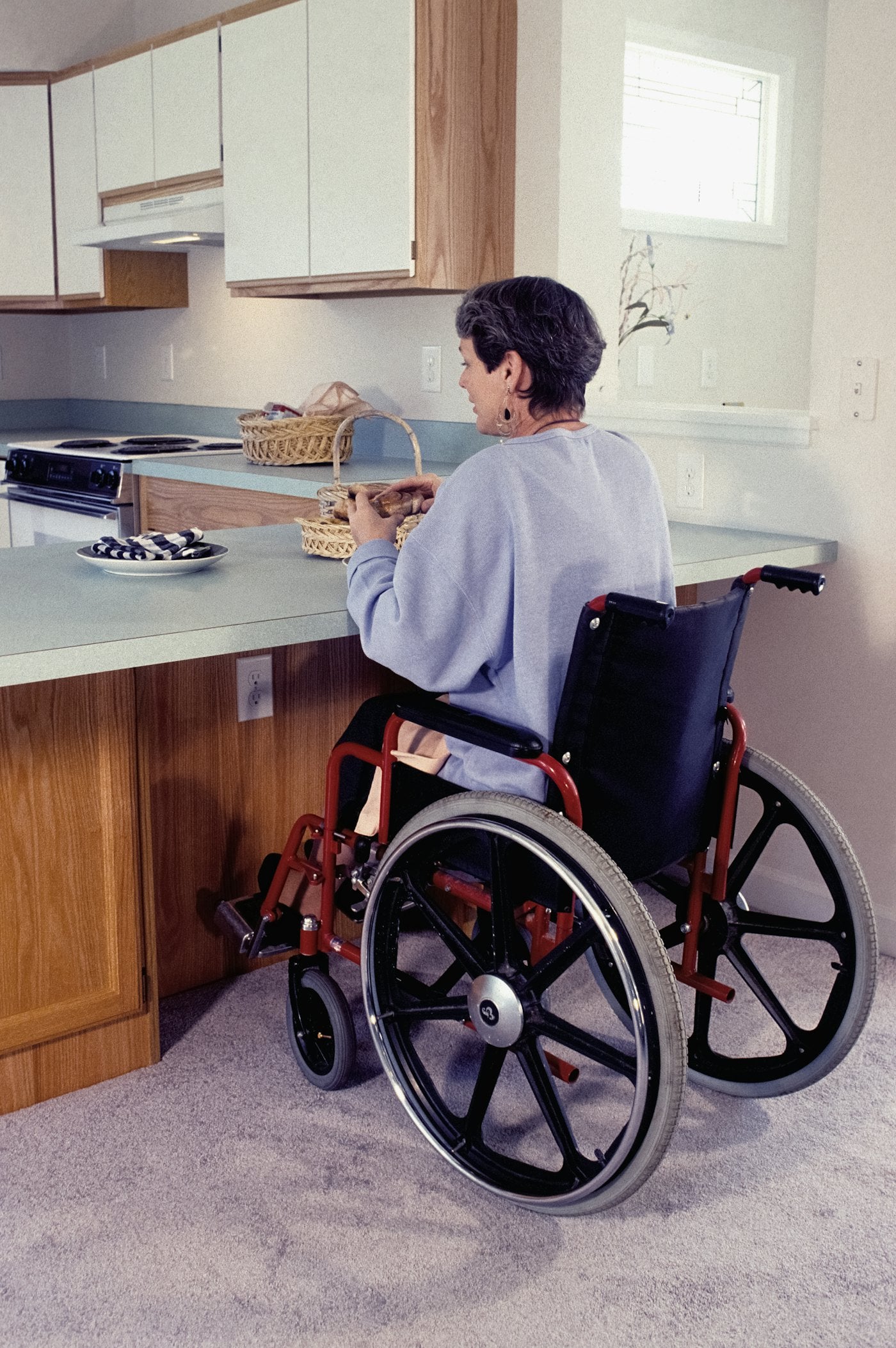 Woman in a wheelchair at her kitchen counter