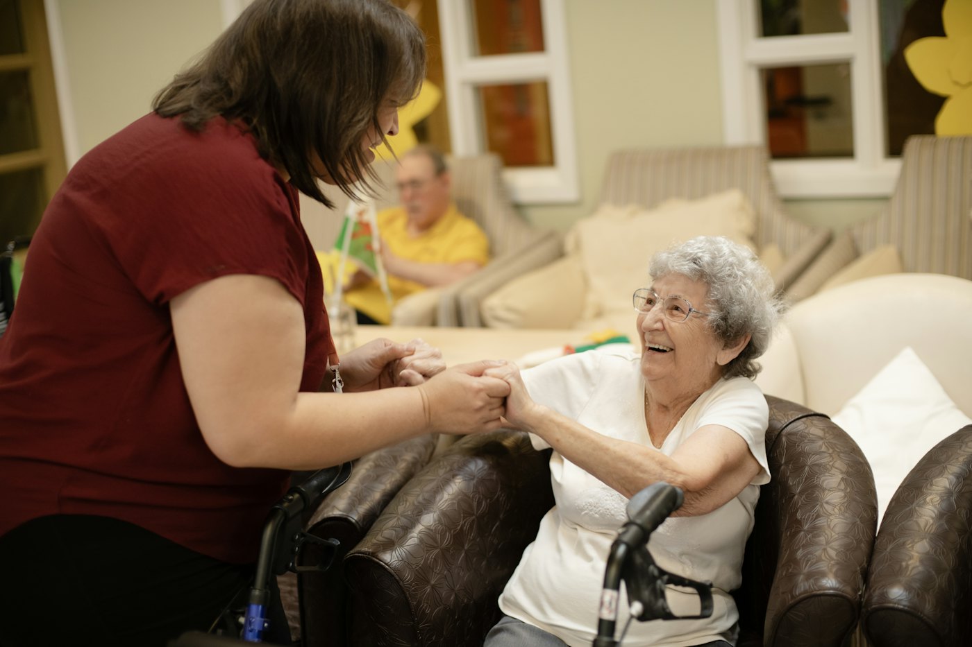 Carer supporting a woman walking with a walker